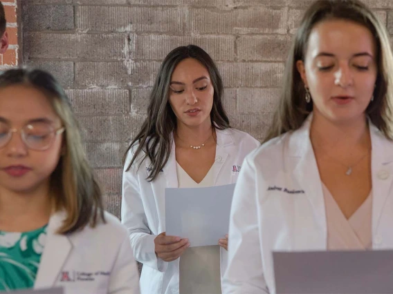 Fran Buranday, Taylor Elinski and Andrea Busicescu recite the oath along with the rest of their class during the ceremony.