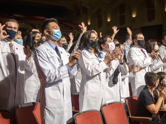 Class of 2025 medical students applaud at the end of their white coat ceremony.