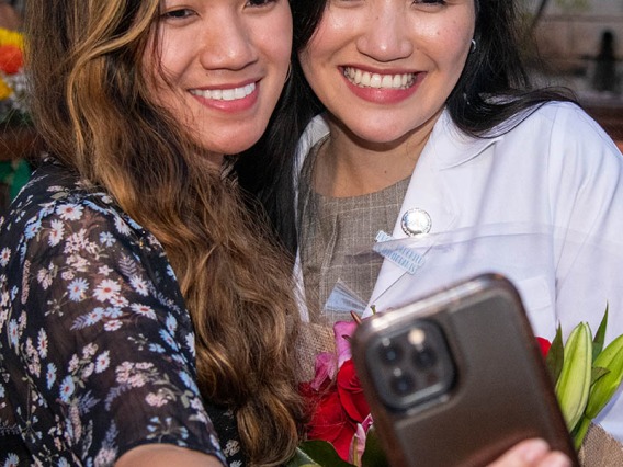 Medical student Bobbie Alcanzo takes a selfie with her sister Bernice Alcanzo after the Class of 2025 white coat ceremony.