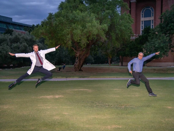 Medical student Matthew Flowers and his father Clifford Flowers jump for joy after Matthew received his white coat at the ceremony.