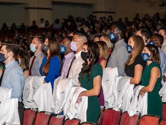 Medical students recite the mission statement during the Class of 2025 white coat ceremony at Centennial Hall.