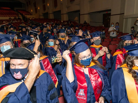 Graduates turn their tassels at the conclusion of the  August commencement at Centennial Hall.