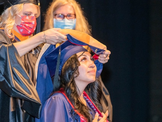 Ariel Alonzo is hooded during the College of Nursing’s August commencement at Centennial Hall.