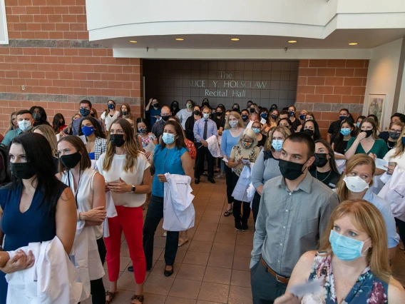 Doctor of Nursing Practice students wait to enter Crowder Hall for their white coat ceremony. 