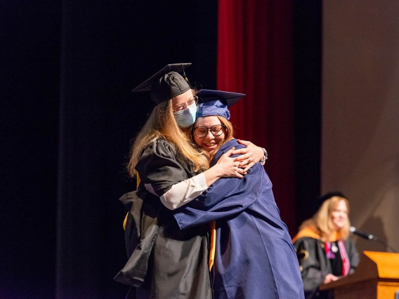 Christine Windes hugs her presenter after receiving her Bachelor of Science in Nursing during the College of Nursing fall convocation.