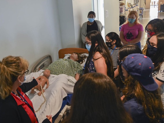 Deana Ann Smith, RN, health care simulation educator for ASTEC, left, shows ACES campers the labor and delivery patient simulator during their tour.