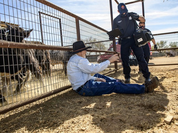 Rio Rico emergency medical technicians set up field equipment to assist rancher Leon Keller with his injury. (Note: This was a simulated accident scene for demonstration purposes.)