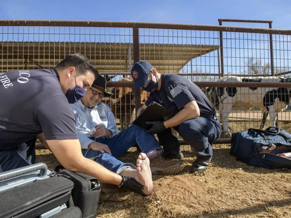 Saenz examines Keller’s foot while Weber uses the AzREADI telehealth technology to contact an emergency medicine physician. (Note: This was a simulated accident scene for demonstration purposes.)