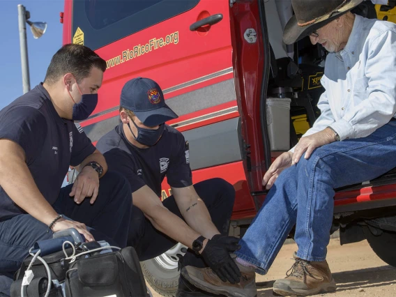 Following a telehealth consultation with Dr. Gaither, Weber helps Keller put his shoe on. (Note: This was a simulated accident scene for demonstration purposes.)