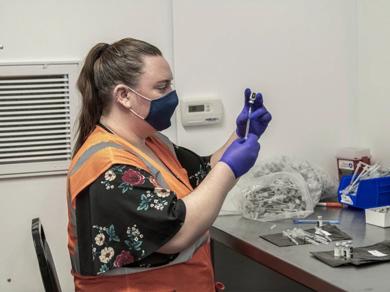 Hiller uses a syringe to measure 0.3 mL of the mixed Pfizer solution that will be given to patients at the University POD.