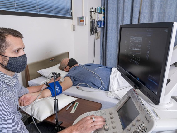 Dallin Tavoian, PhD, uses an ultrasound probe to obtain an image of an artery in the participant's upper arm. The flow-mediated dilation procedure assesses the artery's response to a change in blood flow, an important marker of cardiovascular health.