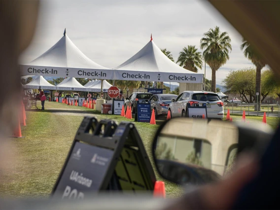 A line of cars approaches the check-in point after their vaccination appointments are confirmed.