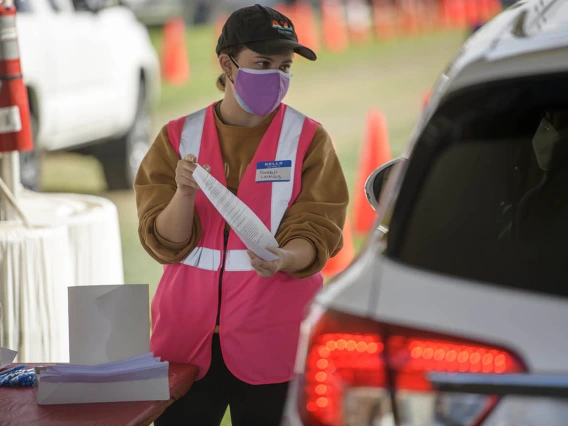 Mel and Enid Zuckerman College of Public Health graduate student Hannah Launius volunteers at the check-in area of the COVID-19 vaccination distribution site on the University of Arizona campus.