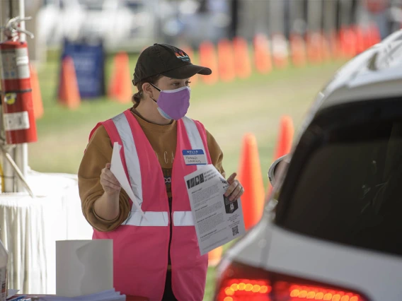 Mel and Enid Zuckerman College of Public Health graduate student Hannah Launius volunteers at the check-in area of COVID-19 vaccination distribution site.