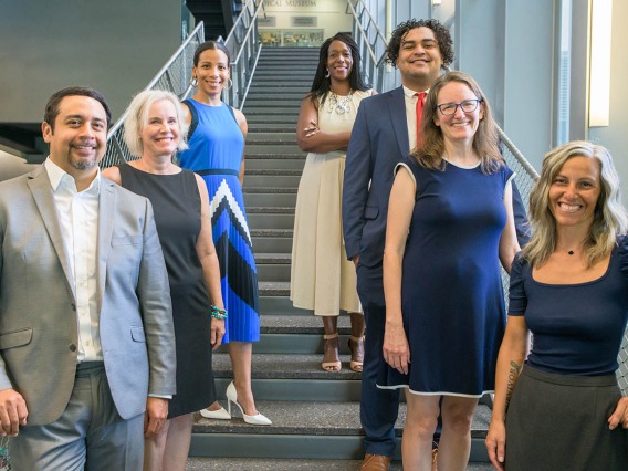 Seven staff members from the University of Arizona College of Medicine – Phoenix Office of Equity, Diversity and Inclusion stand on a staircase.