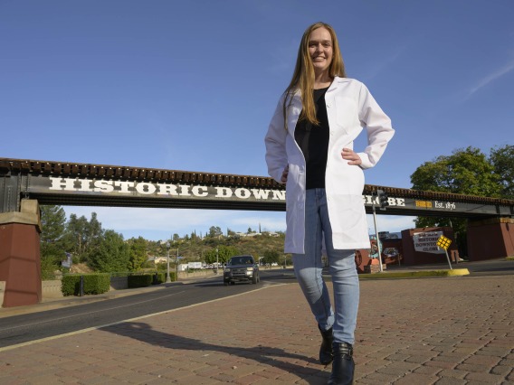 Emma Rautenberg, a first-year medical student at the University of Arizona College of Medicine – Tucson stands in front of a bridge in Globe, Arizona.
