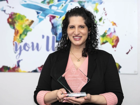 Portrait of Sommer Aldulaimi holding her glass MedGlobal award.