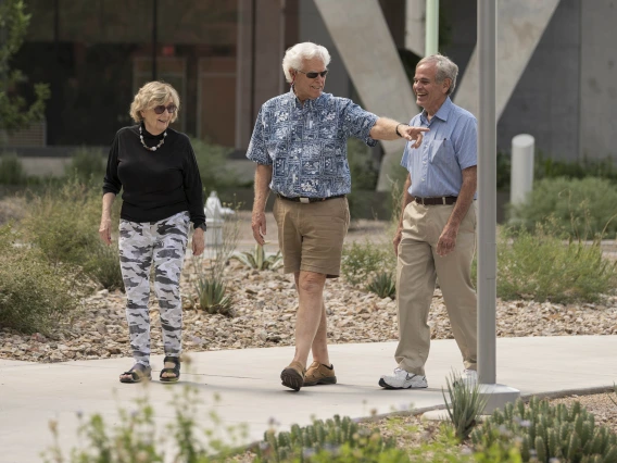 three older adults walk through the University of Arizona Health Sciences campus