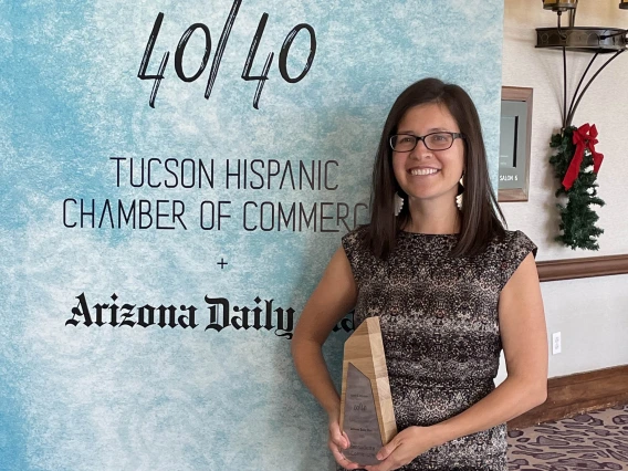 Portrait of Dr. Bernadette Cornelison holding an award while smiling. 