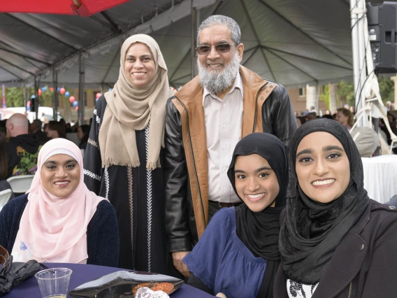 A family sits around a table, all smiling, at the University of Arizona College of Medicine – Tucson Match Day celebration.