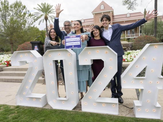 A family stands behind giant “2024” numbers while one of them holds an “I Matched” card up as they celebrate their daughter’s residency match at the University of Arizona College of Medicine – Tucson Match Day celebration. 