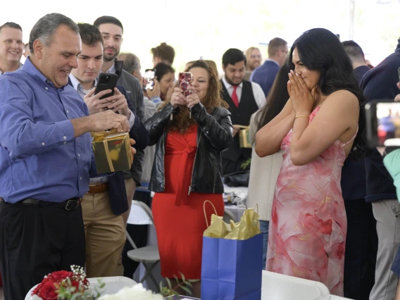 A man reads a sheet of paper as a young woman covers her mouth in anticipation at the University of Arizona College of Medicine – Tucson Match Day celebration. 