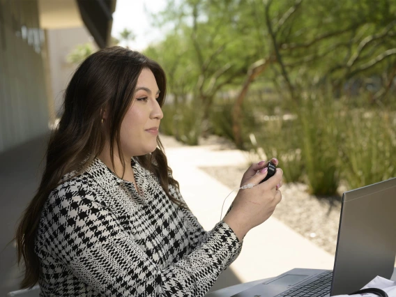 A College of Medicine – Phoenix medical student with Type 1 diabetes using a glucose monitor on herself