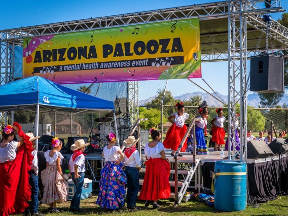 A folklorico group of elementary-school children performs on an outdoor stage at Arizona Palooza