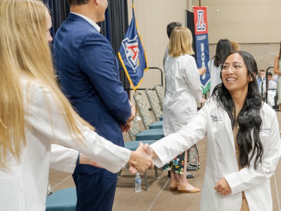 medical student shakes hands with faculty member at the University of Arizona College of Medicine – Phoenix White Coat Ceremony