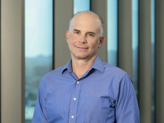 Portrait of Michael Kuhns, PhD, indoors in front of windows