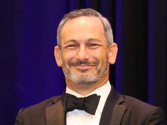 Portrait of Ara Feinstein, MD, MPH, in a tuxedo with black bow tie smiling. 