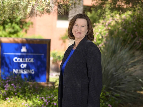 Terry A. Badger, PhD, RN, stands outside near the University of Arizona College of Nursing sign.