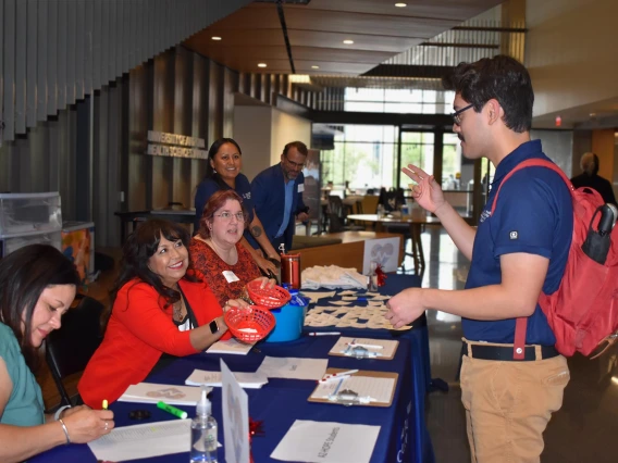 Male student talking with the student services table