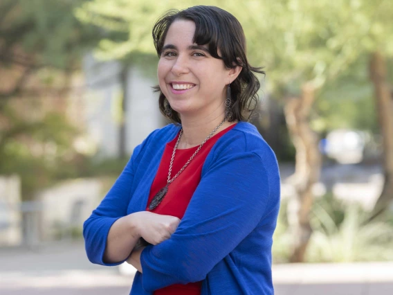 Portrait of Christina Kalel standing outside under trees smiling. 