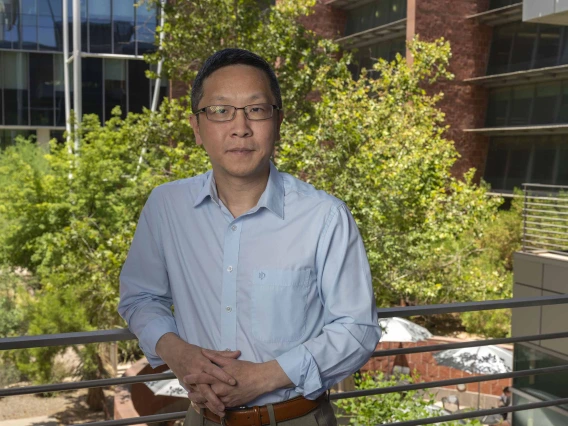 Portrait of Mingyu Liang, MB, PhD, standing outside in front of trees.