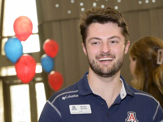 Photo of student Brodie Garrett with red and blue balloons in the background.