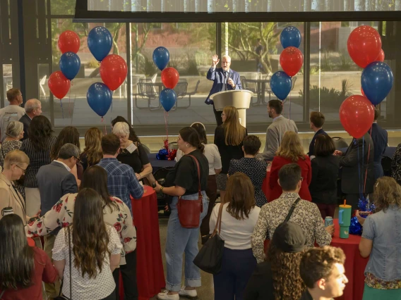 Photo of Kevin Lohenry at a podium as people look toward him. 