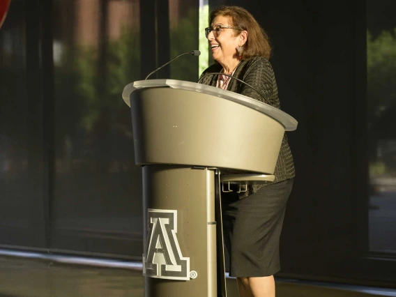 Iman Hakim, MD, PhD, MPH, dean of the Zuckerman College of Public Health, stands at a podium.