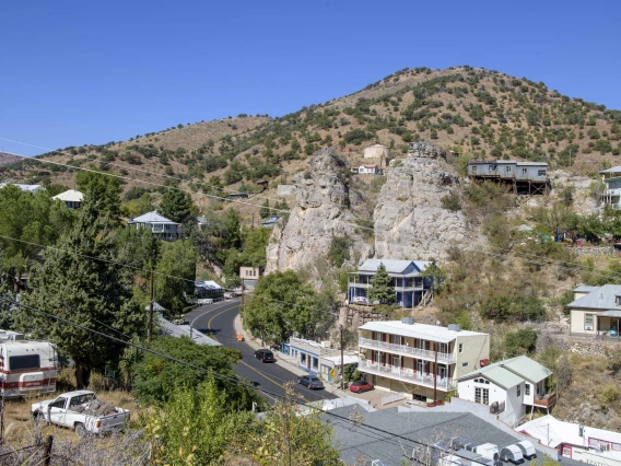 Aerial view of town of Bisbee, Arizona, showing main road, houses, hotel, store, with mountains in background