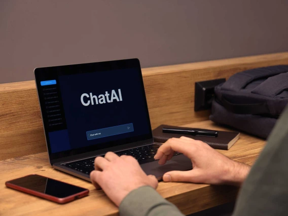person using laptop with the words “ChatAI” on a black screen with a text prompt