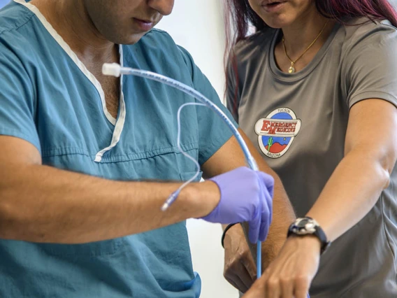 An emergency medicine student practices placing a tracheostomy tube using a simulated airway.