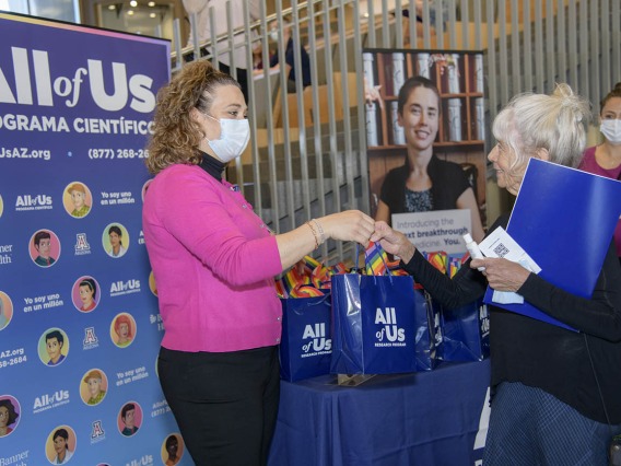 All of Us UArizona-Banner engagement coordinator, Erika Davila Rivas, welcomes Mary Douglas, an All of Us participant, at the 50k Strong Arizona Celebration and Research Showcase in the Health Sciences Innovation Building on the Tucson Campus.