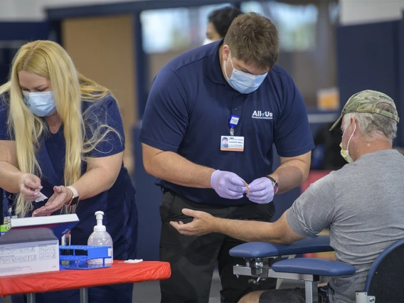 Health care workers assist with blood sample collection. More than 4,500 people are scheduled to have their blood drawn in the first few days of testing.