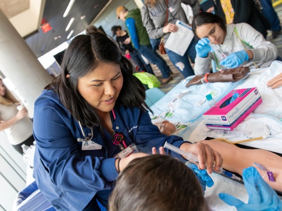 Students from the University of Arizona College of Nursing demonstrate administering an IV to a manikin during the Connect2STEM event in Phoenix in January.