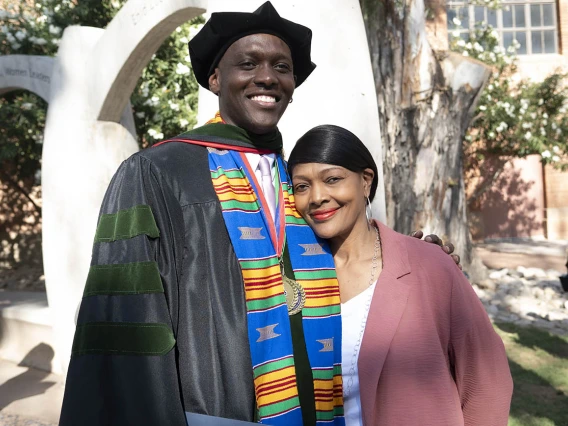 Caylan Bookman, MD, hugs his mother, Sheryl Williams, outside of Centennial Hall after the College of Medicine – Tucson class of 2022 convocation. 