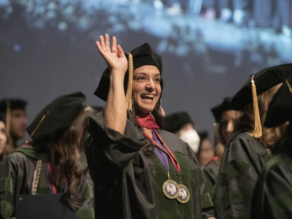 Sara Ali Fermawi, MD, waves out to the audience at the end of the College of Medicine – Tucson class of 2022 convocation ceremony at Centennial Hall.