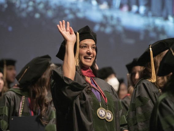 Sara Ali Fermawi, MD, waves out to the audience at the end of the College of Medicine – Tucson class of 2022 convocation ceremony at Centennial Hall.