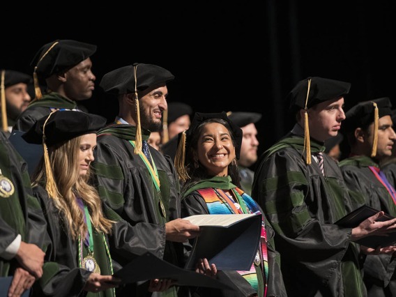 Naiby Rodriguez Zuniga, MD, (center smiling) can’t hide her excitement as she and her classmates prepare to recite the Hippocratic Oath at the end of their College of Medicine – Tucson class of 2022 convocation ceremony at Centennial Hall.