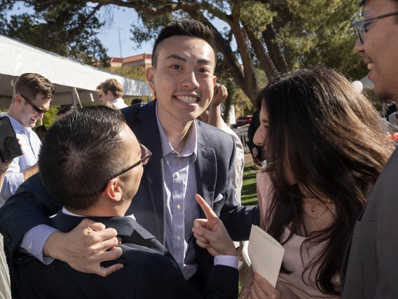 Young Asian man with big smile is hugged by friends. 