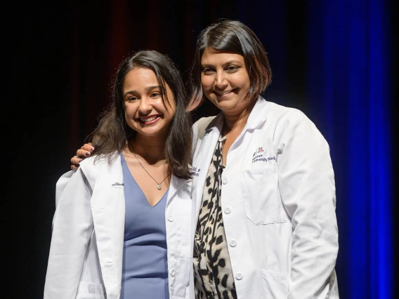 Nandini Sodhi pauses for a photo with Serena Scott, MD, assistant professor of medicine, during the UArizona College of Medicine – Tucson Class of 2026 white coat ceremony.